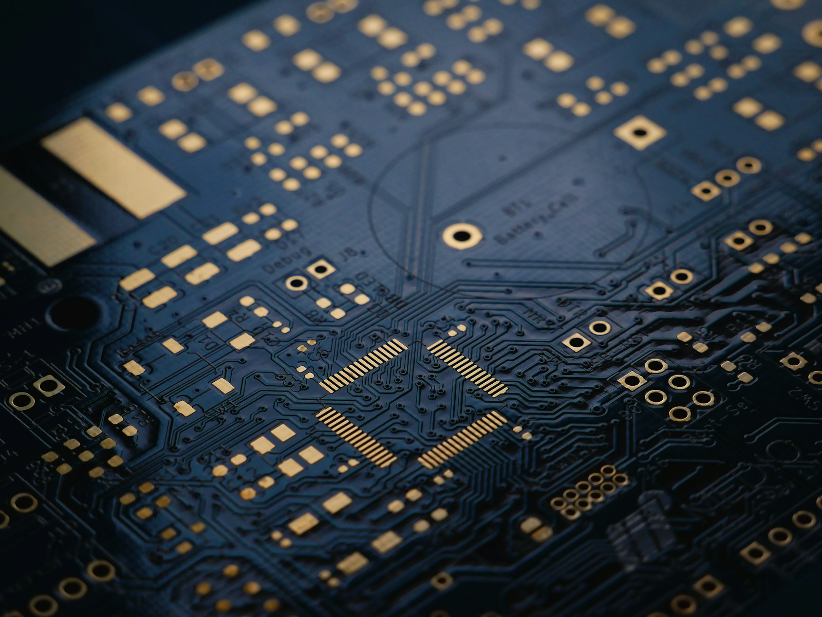 Macro view of a dark blue circuit board with gold traces